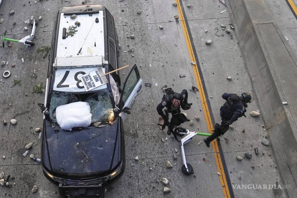 $!Dos agentes de la Patrulla de Carreteras de California intentan esquivar piedras lanzadas cerca del Centro de Detención Metropolitano en el centro de Los Ángeles.