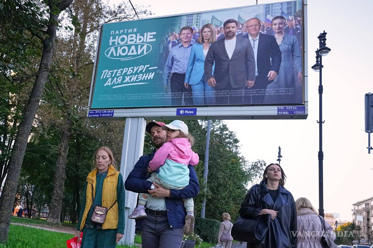 $!Unas personas pasan frente a una valla publicitaria en San Petersburgo que promociona al partido Nueva Gente de cara a las elecciones parlamentarias.