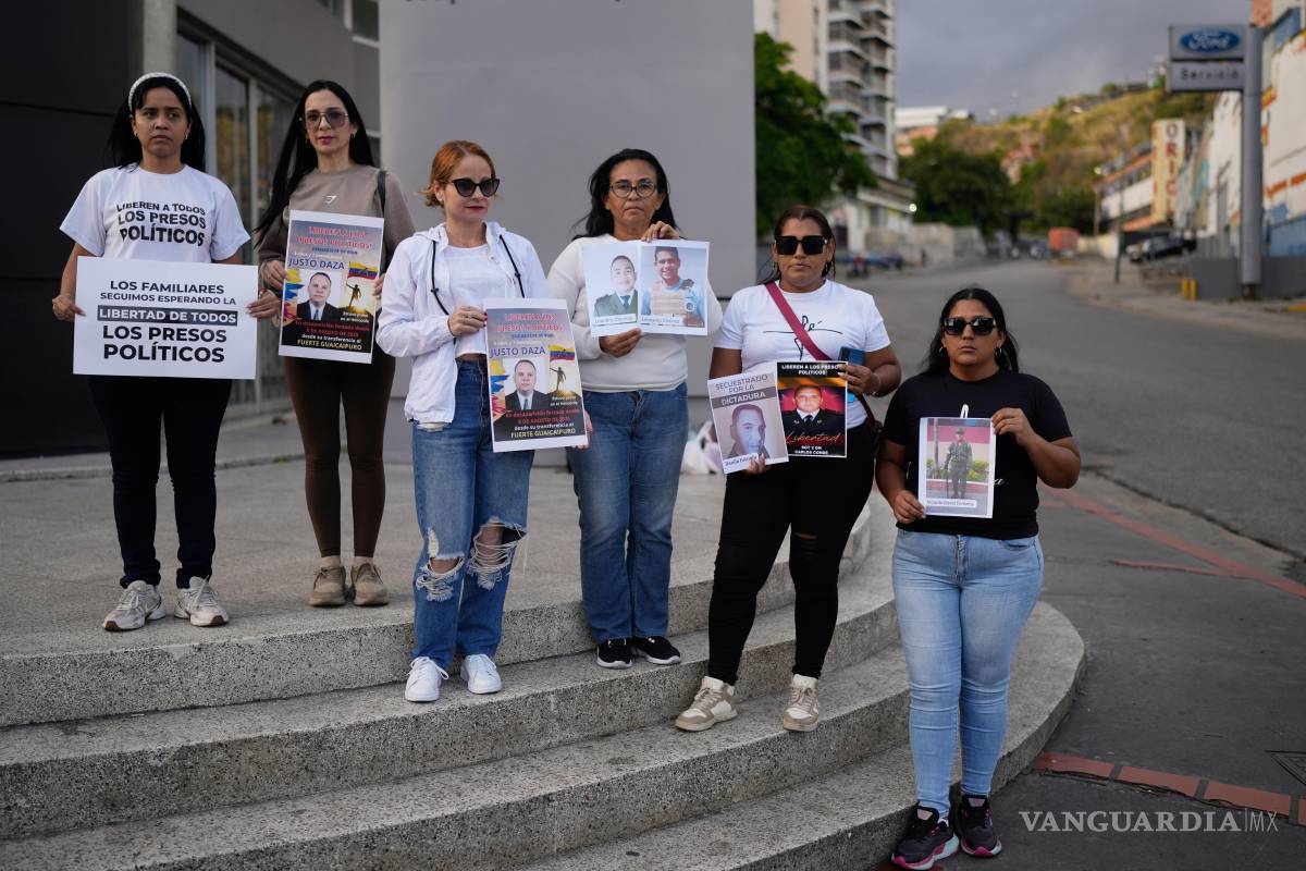 $!Familiares de detenidos sostienen carteles cerca de El Helicoide, sede del servicio de inteligencia venezolano y centro de detención, en Caracas, Venezuela.