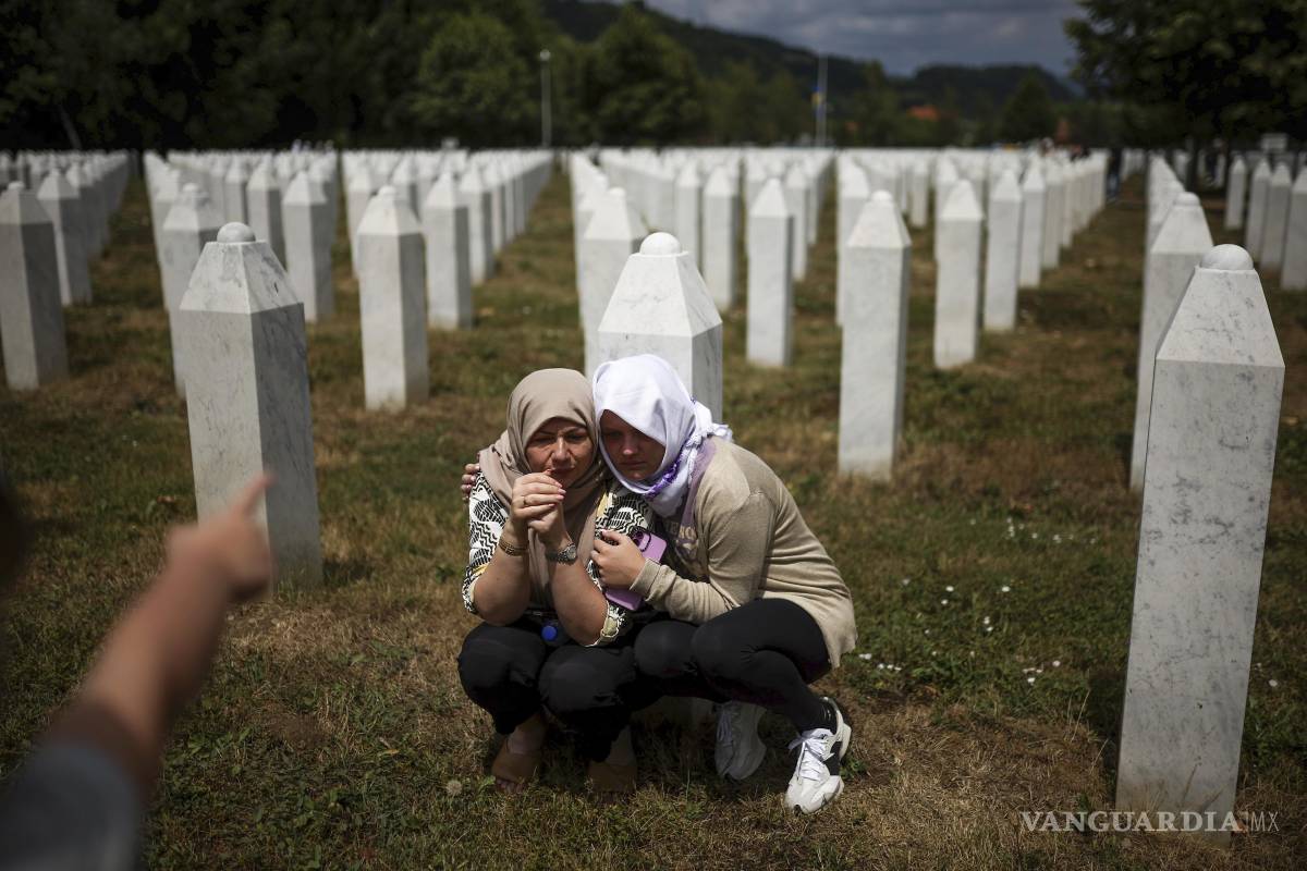 $!Familiares lloran junto a la tumba de su pariente, víctima del genocidio de Srebrenica, antes de la ceremonia de entierro masivo en Potocari, Bosnia.