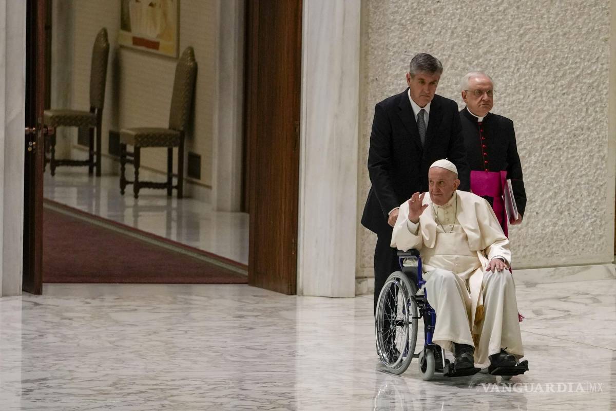 $!El Papa Francisco llega en silla de ruedas para asistir a una audiencia con monjas y superiores religiosos en el Aula Pablo VI del Vaticano.