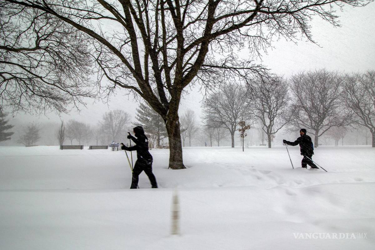 $!Dos personas se desplazan en esquís este domingo, en el centro de Toronto, Canadá.