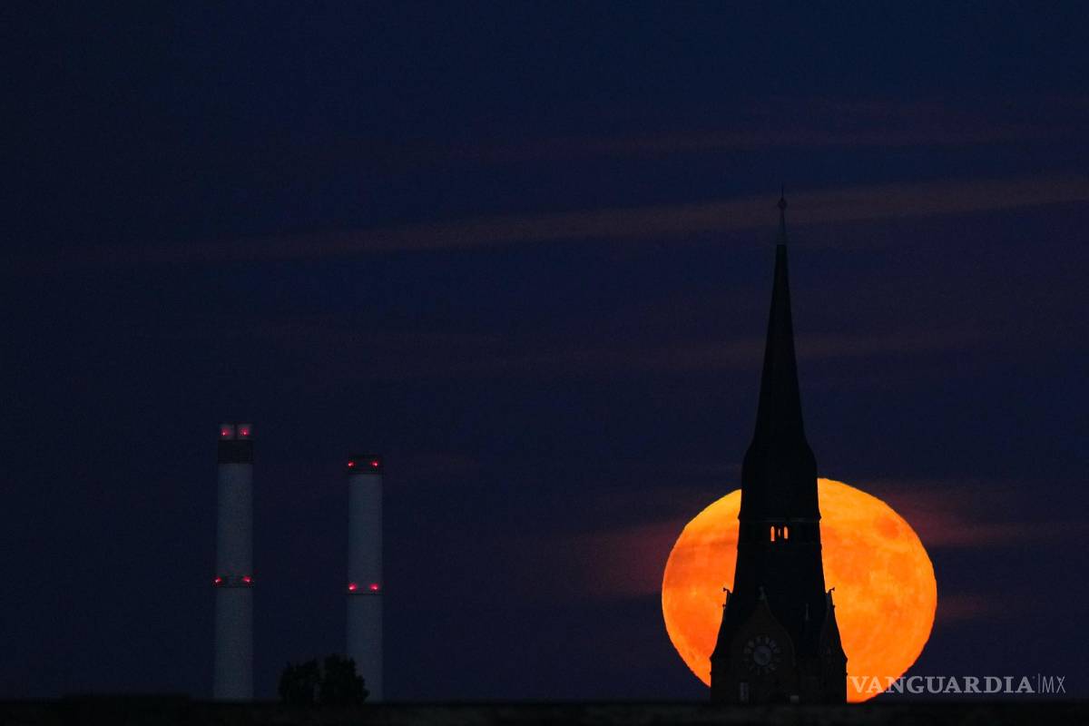 $!La luna llena de fresas se eleva detrás de una iglesia en Berlín, Alemania. Durante un fenómeno conocido como la “ Strawberry Moon”.
