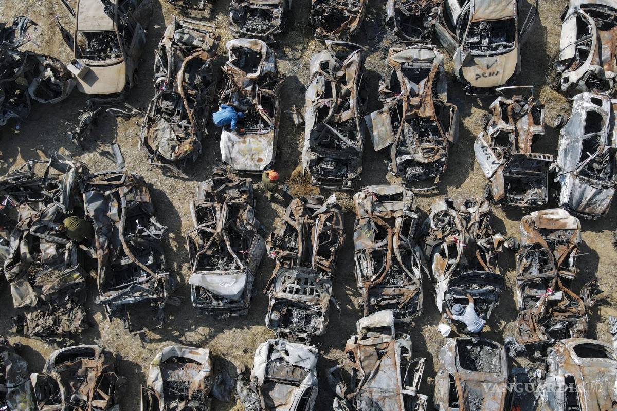 $!Las fuerzas de seguridad israelíes inspeccionan vehículos calcinados en el ataque de Hamás el 7 de octubre, a las afueras de la localidad de Netivot, Israel.