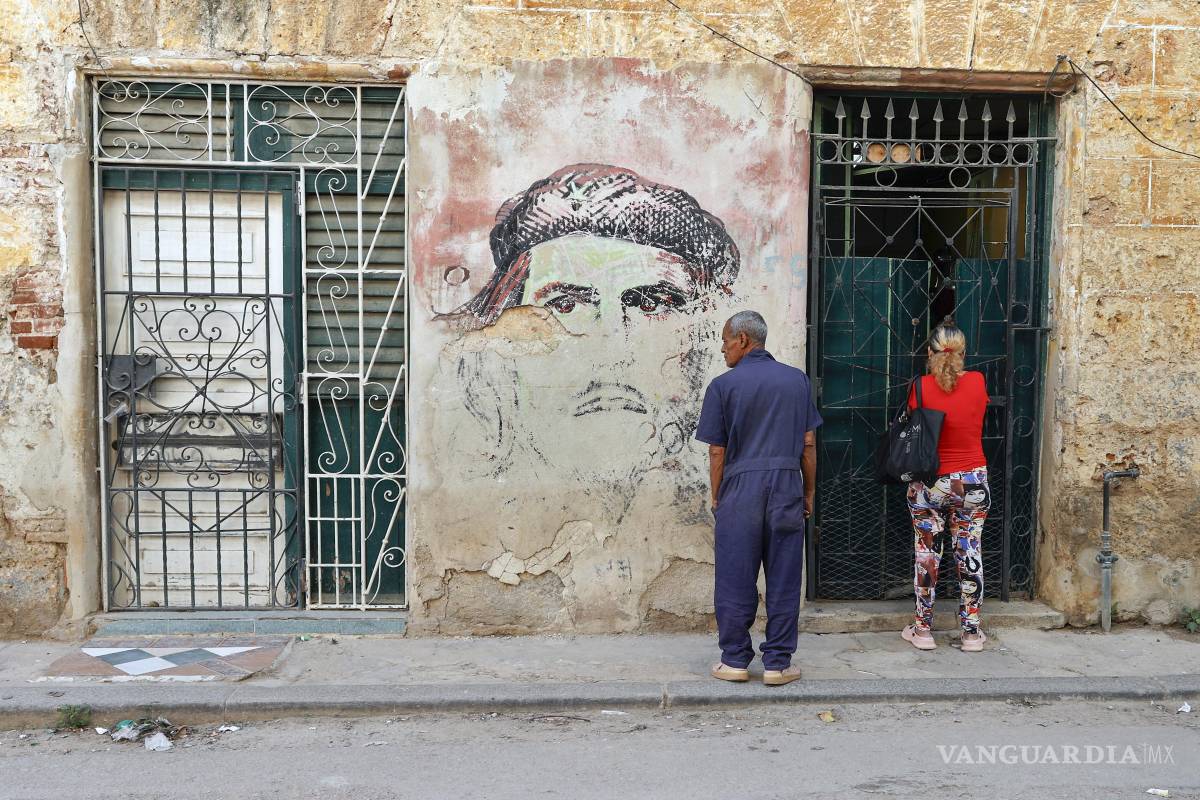 $!Personas esperan a que les abran la puerta frente a un mural con la imagen de Ernesto 'Che' Guevara en La Habana, Cuba.