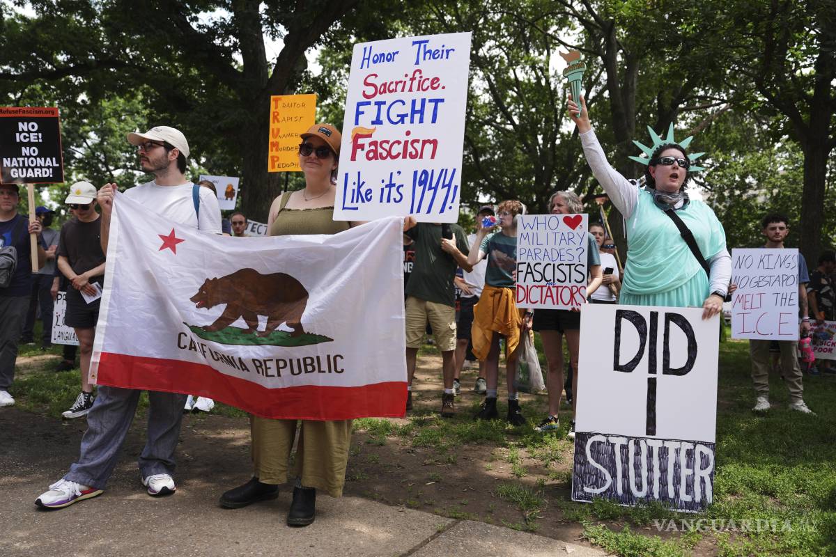 $!Manifestantes sostienen letreros durante una protesta el día de un desfile militar por el 250mo aniversario del Ejército, el cual coincidió con el cumpleaños 79 del presidente Donald Trump en Washington.
