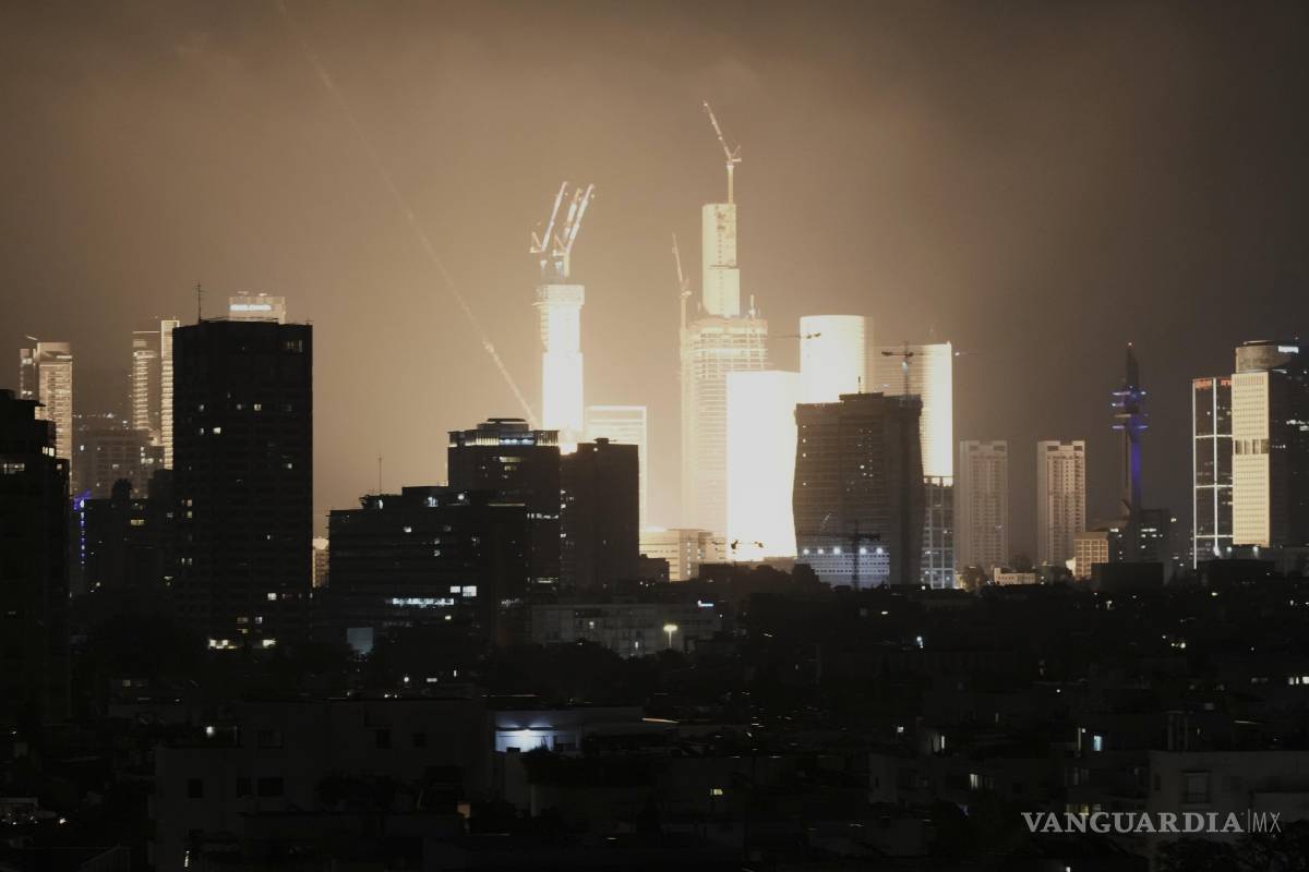 $!Una explosión causada por el impacto de un proyectil ilumina el horizonte de Tel Aviv, Israel, a primera hora de la mañana.