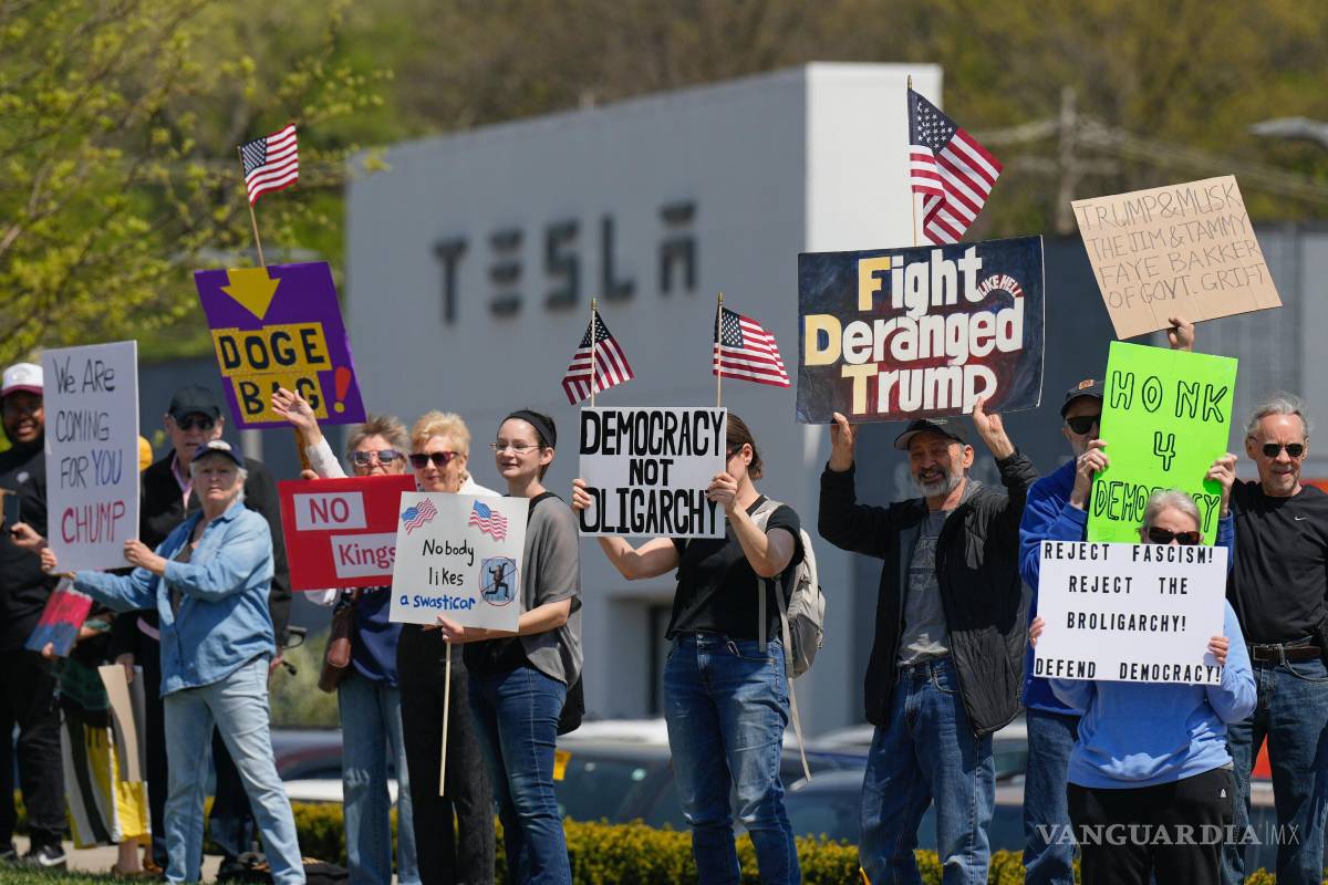 $!Manifestantes protestan contra Elon Musk y los recortes del DOGE frente a un concesionario de Tesla, el sábado 12 de abril de 2025, en Kansas City, Missouri.