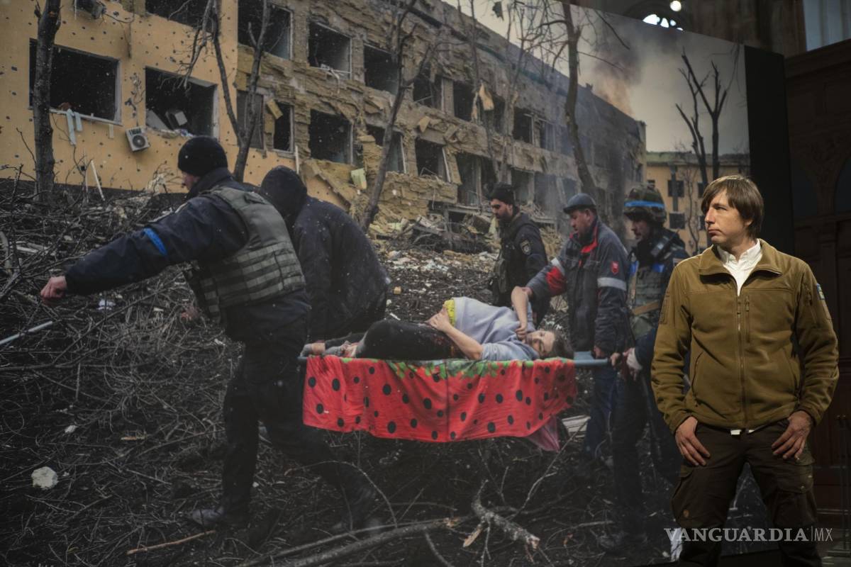 $!El ganador del premio World Press Photo of the Year, el fotógrafo de Associated Press Evgeniy Maloletka, frente a su imagen en Ámsterdam, Países Bajos.