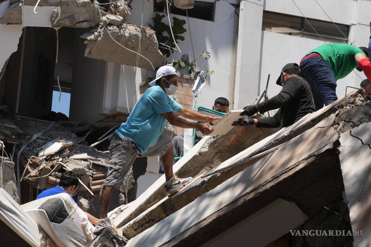 $!AME7690. CALI (COLOMBIA), 10/08/2026.- Integrantes del cuerpo de Bomberos de Cali y civiles buscan entre los escombros de edificaciones colapsadas por el terremoto de magnitud 7,4 que sacudió esta mañana el país, este lunes en Cali (Colombia). El Gobierno colombiano declaró la situación de desastre nacional por el terremoto que deja al menos 71 personas fallecidas en el país, 29 de ellas en ciudades capitales. EFE/ Ernesto Guzmán Jr