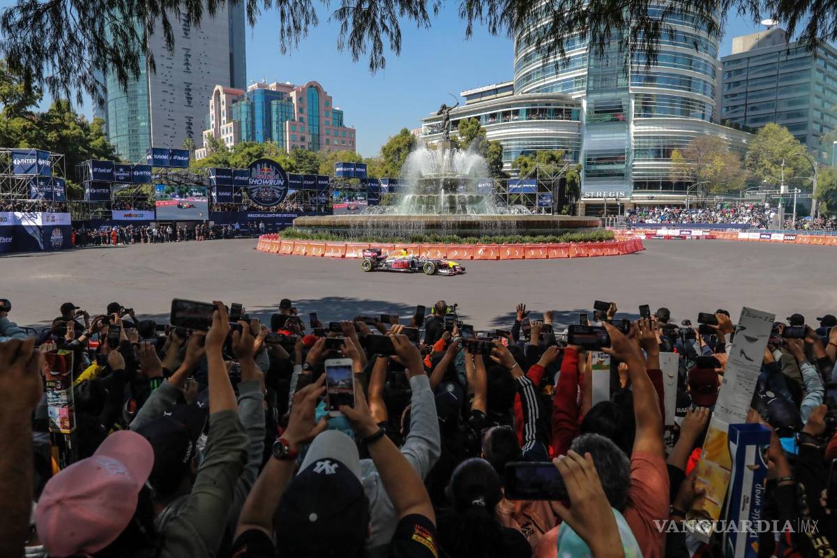 $!Aficionados toman hoy fotos mientras pasa el piloto mexicano de la escudería Red Bull de la Fórmula Uno, Sergio Checo Pérez, durante su Red Bull Show Run en la Glorieta de La Diana Cazadora en el Paseo de la Reforma, en Ciudad de México. EFE/David Guzmán