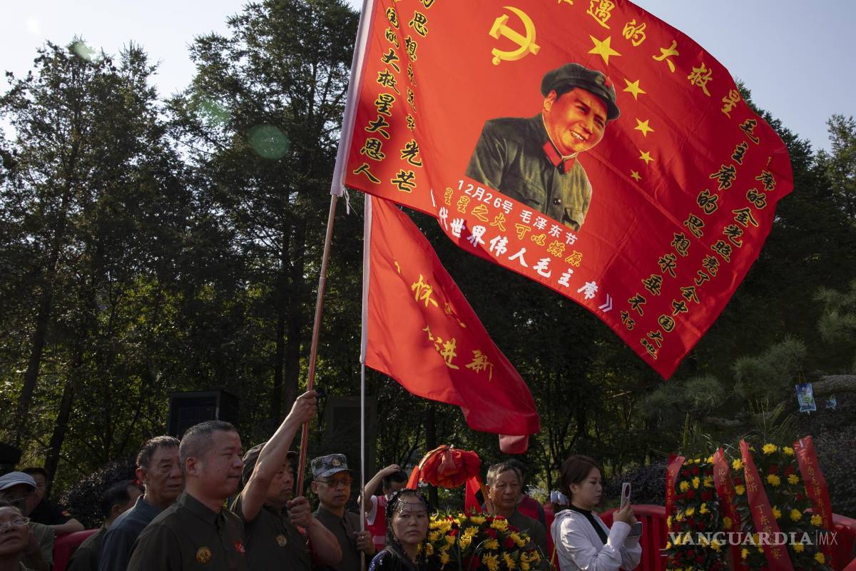 $!Personas sostienen banderas frente a la estatua de Mao Zedong durante las conmemoraciones del 50.º aniversario de su muerte en Shaoshan, China.