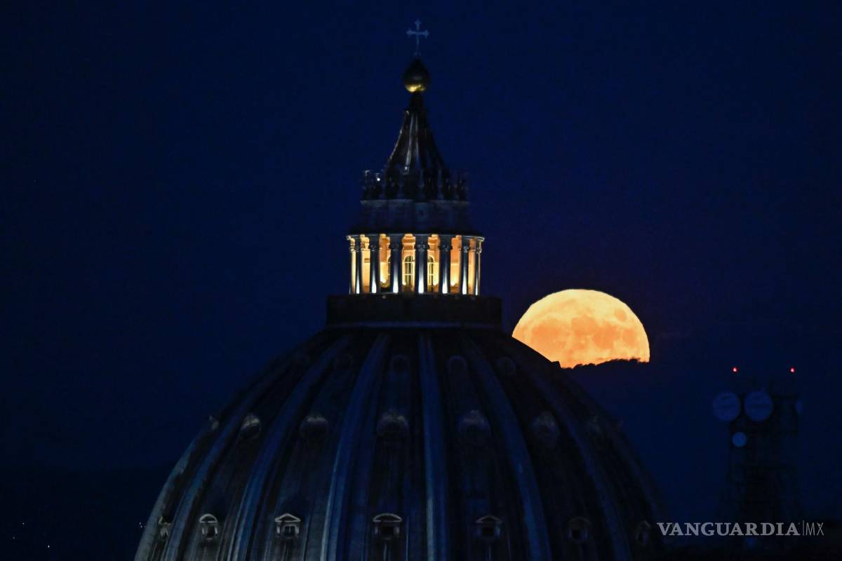 $!La Súper Luna llamada “Luna del Ciervo” se eleva en el cielo detrás de la cúpula de la Basílica de San Pedro en la Ciudad del Vaticano vista desde Roma, Italia.