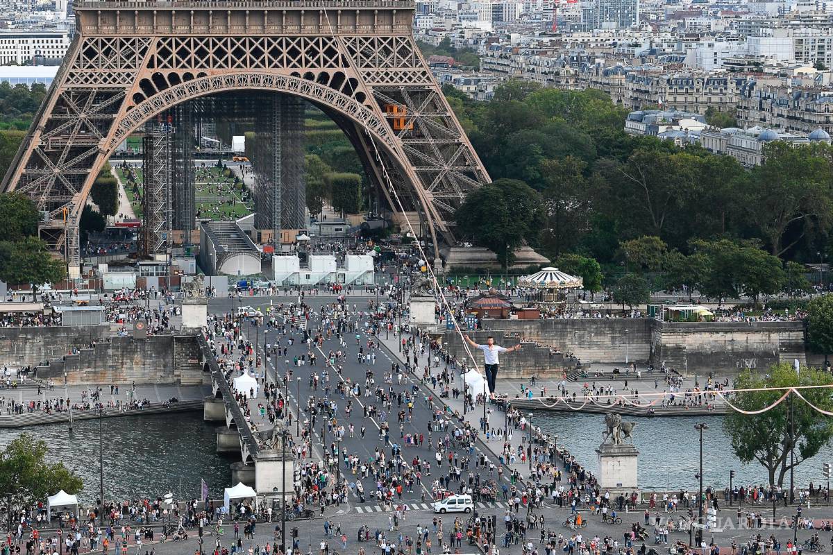 $!El acróbata francés Nathan Paulin camina por una línea alta desde la Torre Eiffel a través del río Sena, como parte de los eventos en Francia para los Días del Patrimonio Nacional en París. AP/Alain Jocard