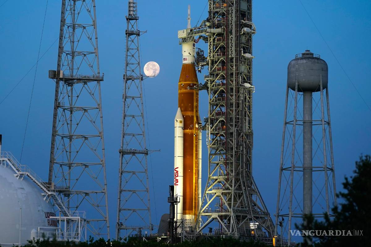 $!La Strawberry Supermoon se pone frente al cohete Artemis de la NASA con la nave espacial Orion a bordo en la plataforma 39B en el Centro Espacial Kennedy.