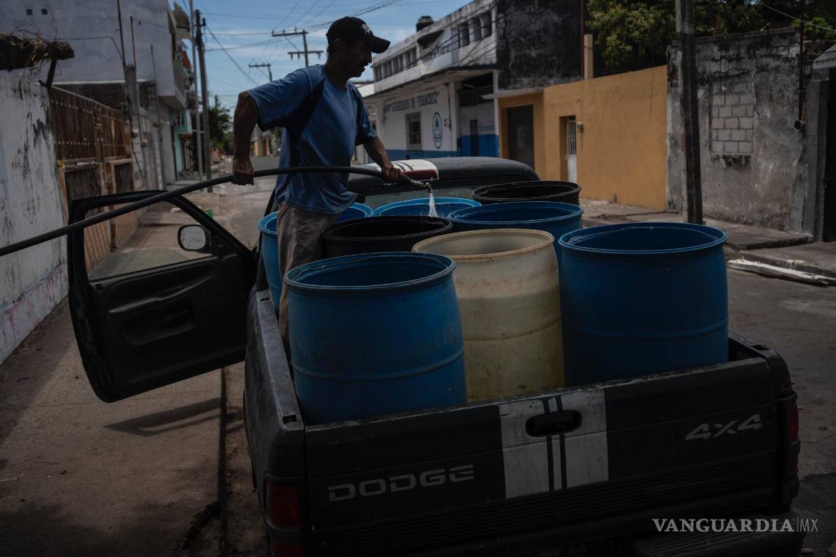 $!Un hombre llena bidones con agua debido a la escasez causada por las altas temperaturas y la sequía en Veracruz, México.