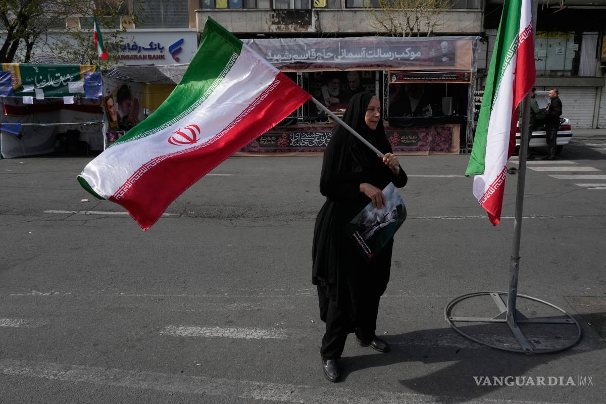 $!Una mujer ondea una bandera iraní durante una campaña a favor del gobierno en la plaza de la Revolución Islámica en el centro de Teherán, Irán.