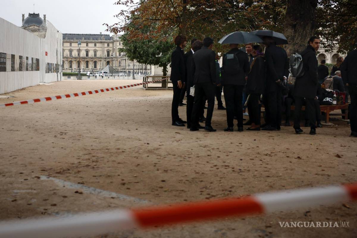 $!Empleados esperan después de la evacuación del Museo de Louvre en París, el sábado 14 de octubre de 2023.
