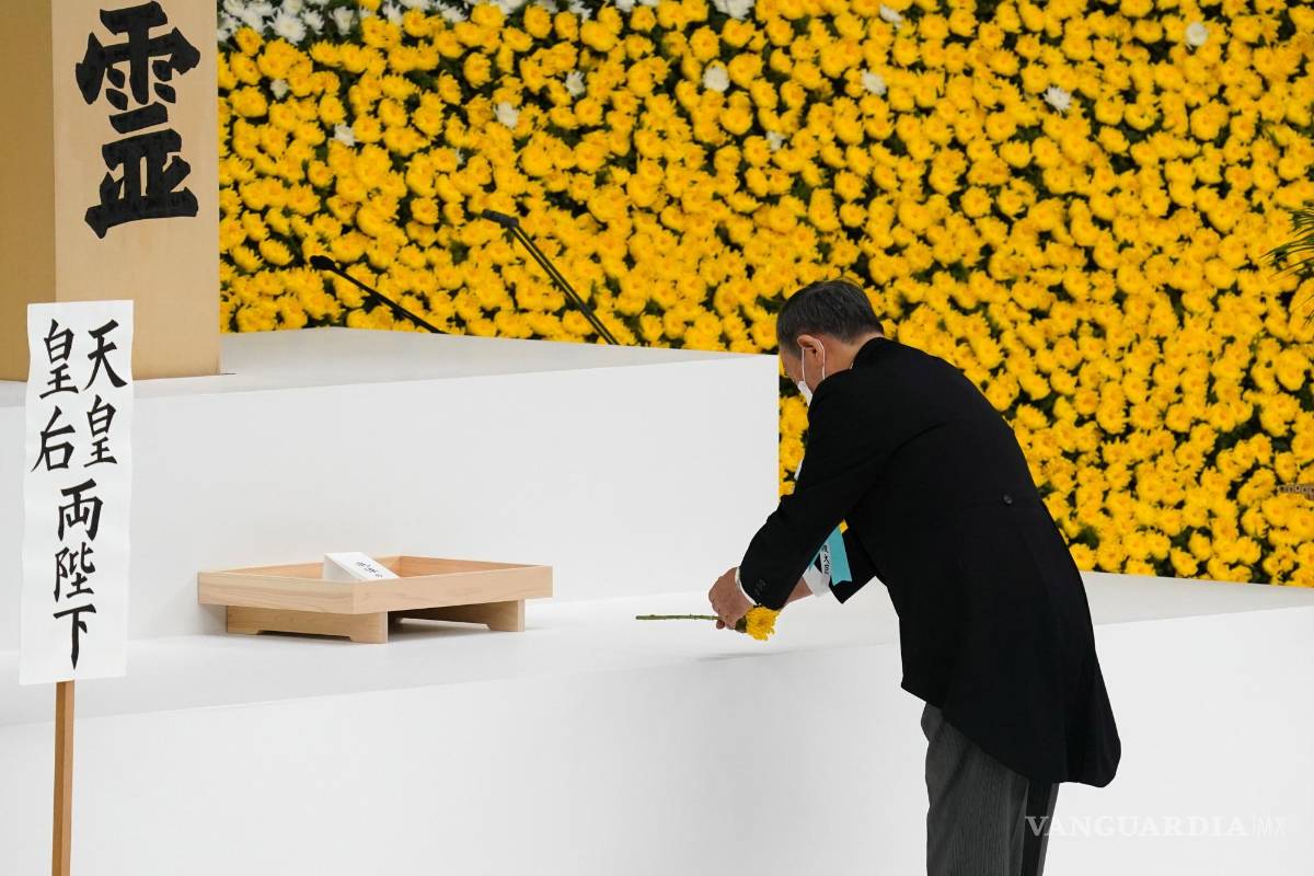$!Yoshihide Suga, primer ministro de Japón, usa una máscara protectora mientras coloca una flor durante un servicio conmemorativo del 76 aniversario del fin de la Segunda Guerra Mundial en Tokio, Japón. EFE/Toru Hanai