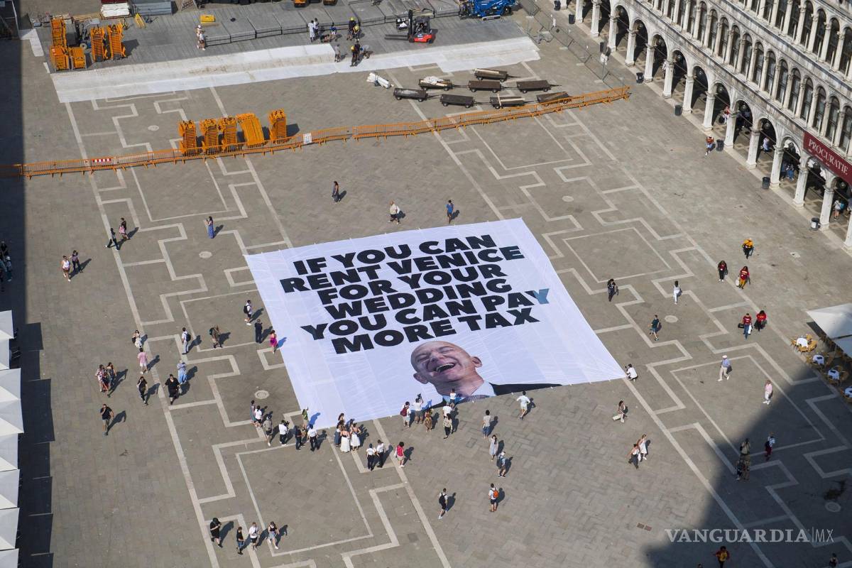 $!Activistas de Greenpeace despliegan una pancarta gigante con la imagen deJeff Bezos, que dice ‘Si puedes alquilar Venecia para tu boda, puedes pagar más impuestos’ en la Plaza de San Marcos en Venecia.