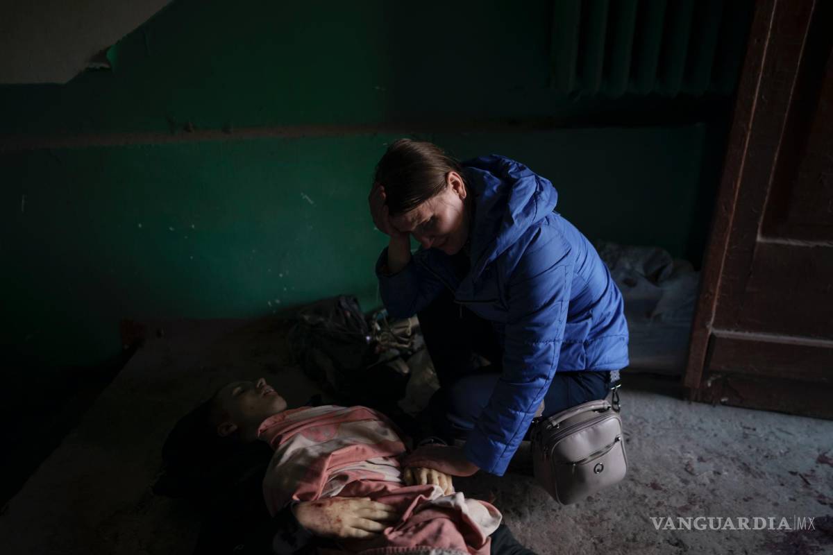 $!Nina Shevchenko llora sobre el cuerpo de su hijo de 15 años, Artem Shevchenko, asesinado en un ataque ruso en Járkiv, Ucrania, el viernes 15 de abril de 2022.