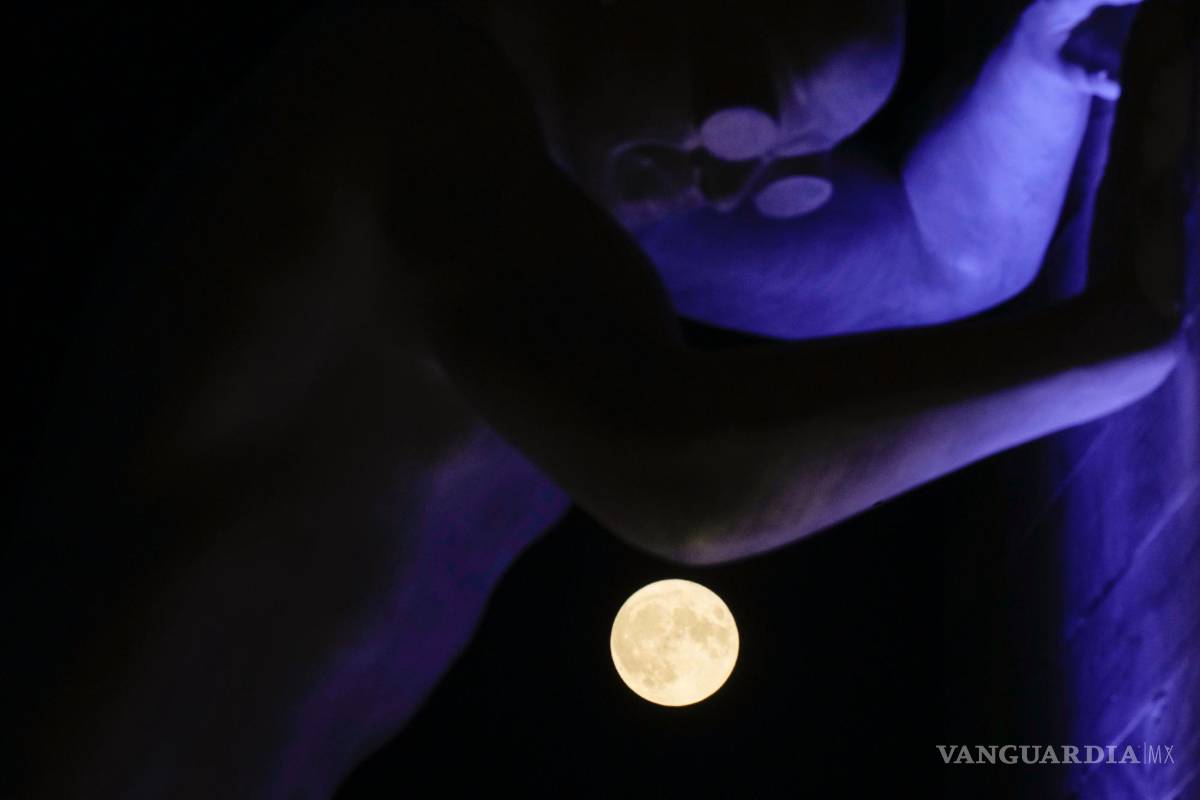 $!La luna llena, vista detrás de la escultura Mr Arbitrium, del artista Emanuele Giannelli, que se apoya en el Arco de la Paz, en Milán, Italia, el 13 de julio de 2022.