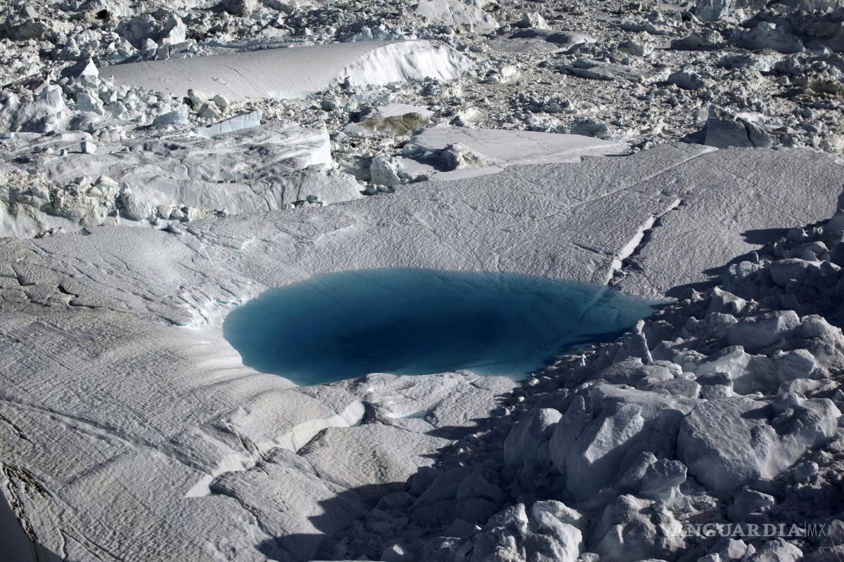 $!En esta fotografía de archivo del 19 de julio de 2011, se forma un gran charco de deshielo en el fiordo de hielo Ilulissat debajo del glaciar Jakobshavn, en el borde de la vasta capa de hielo de Groenlandia. El Ártico se está calentando tres veces más rápido que el resto del planeta y está al filo de la supervivencia. AP/Brennan Linsley