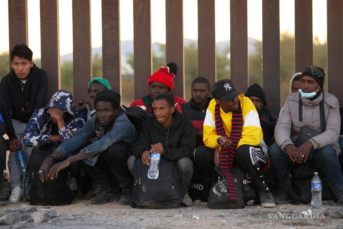 $!Los migrantes se alinean a lo largo del muro fronterizo estadounidense para ser procesados por la Patrulla Fronteriza estadounidense en Lukeville, Arizona.