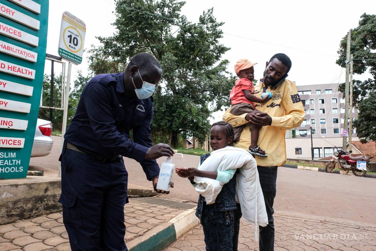 $!Una niña se desinfecta las manos frente al Hospital Musulmán de Kibuli, el sábado 16 de mayo de 2026, en Kampala, Uganda.