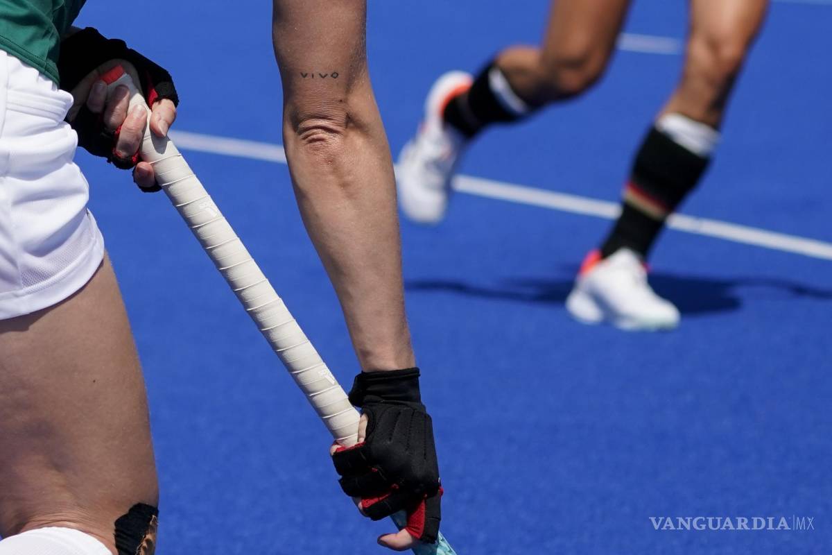 $!La irlandesa Nicola Daly busca pasar el balón mientras se ve un tatuaje que dice “VIVO” en su brazo derecho durante un partido de hockey femenino contra Alemania. (AP Photo/John Minchillo)