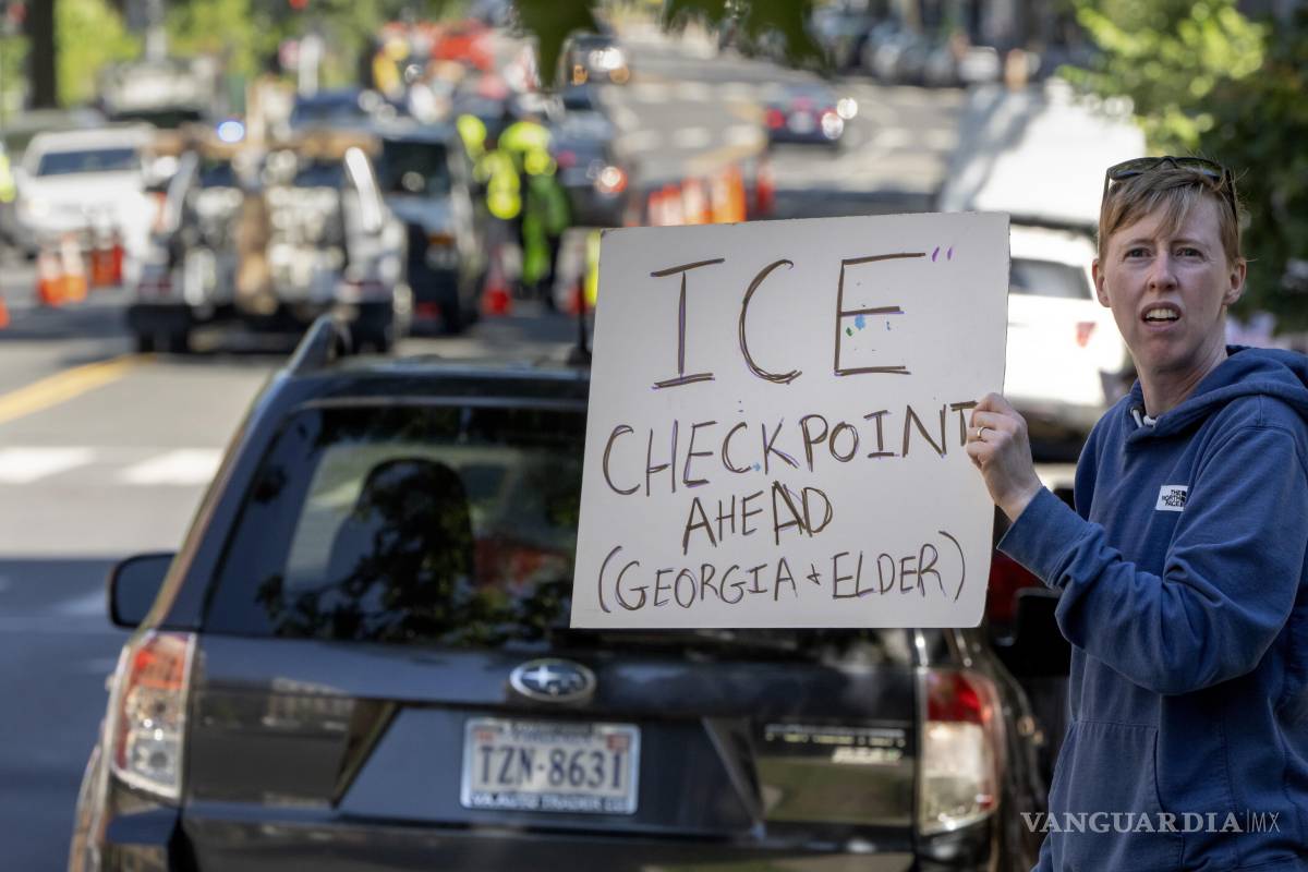 $!Una persona advirtiendo a los conductores sobre un puesto de control policial en la avenida Georgia, en el norte de Washington, llevado a cabo por el ICE) y el HSI.