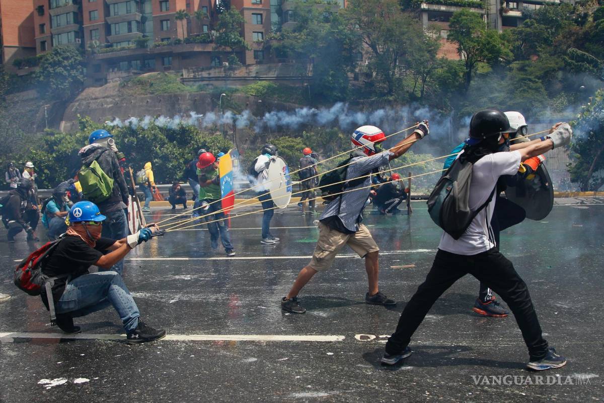 $!Manifestantes contra el gobierno lanzan una botella con material fecal a las fuerzas de seguridad que impiden el paso de la marcha rumbo a la Corte Suprema.