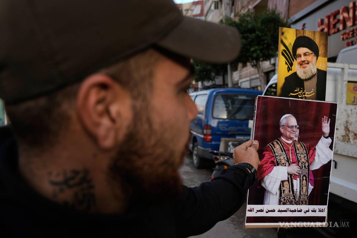 $!Un simpatizante de Hezbolá sostiene fotografías del exlíder del grupo, Hassan Nasrallah y del Papa León XIV en Beirut, Líbano.
