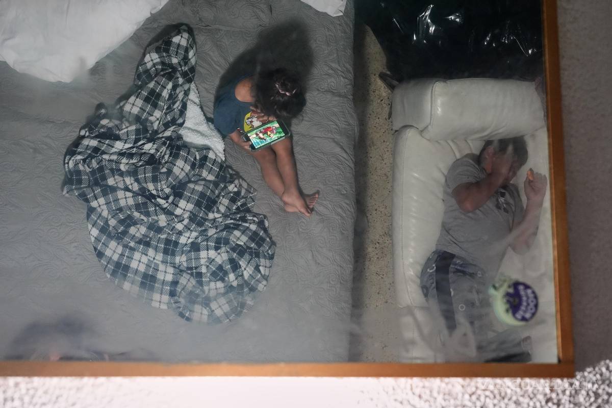 $!Imagen de dos hermanos se refleja en el espejo del techo de la habitación de motel donde viven en Miami con su madre, luego de que su padre fue deportado.