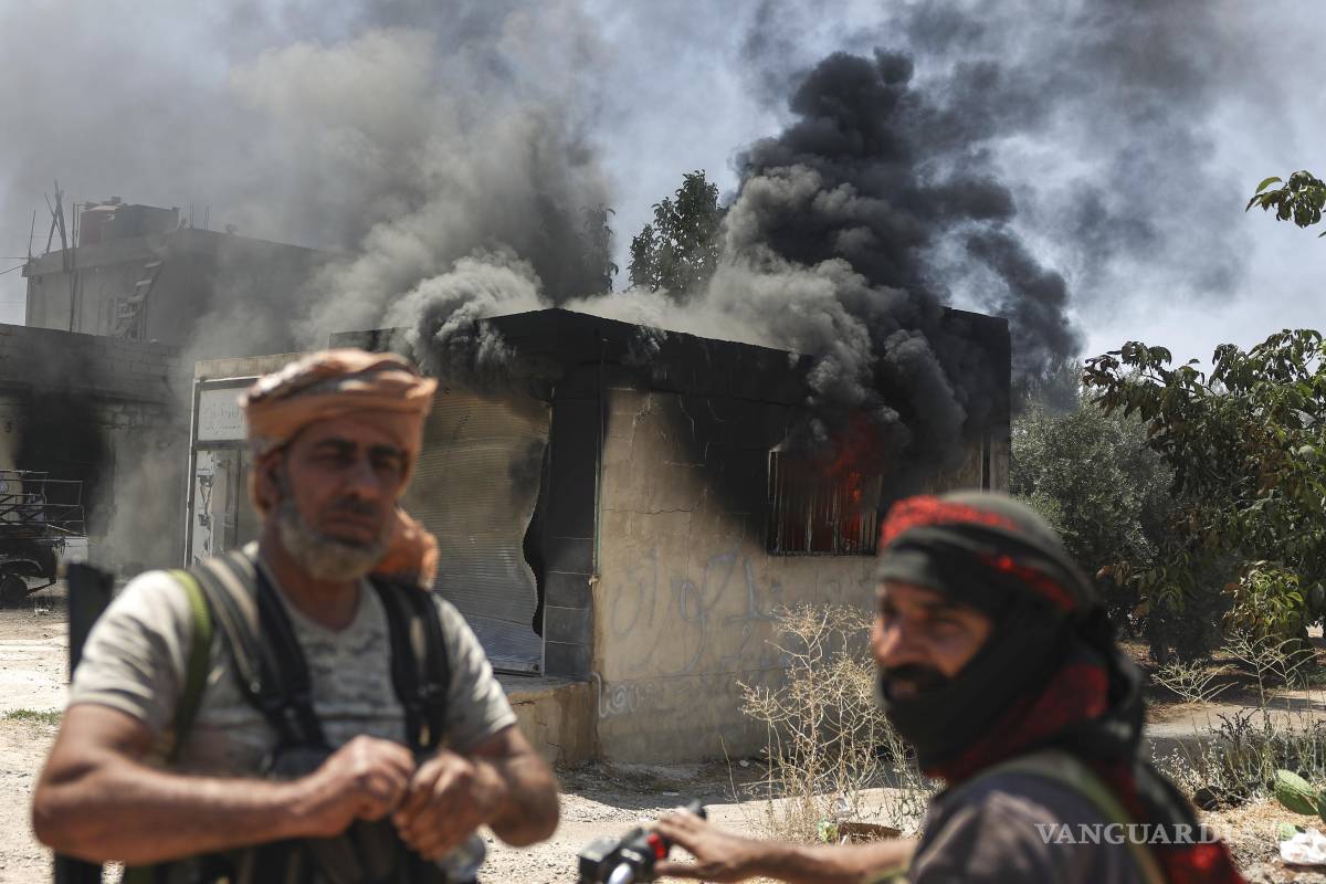 $!Combatientes beduinos, frente a una tienda quemada en Mazraa, durante enfrentamientos entre clanes beduinos y milicias rusas, en el sur de Siria.