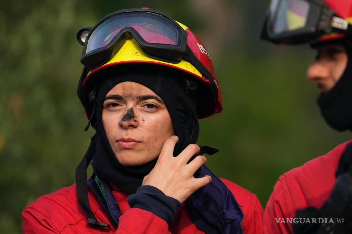 $!Los bomberos se toman un descanso después de combatir un incendio forestal que estalló nuevamente en el pueblo de Lagoa Parada, cerca de Ansiao, en Portugal.