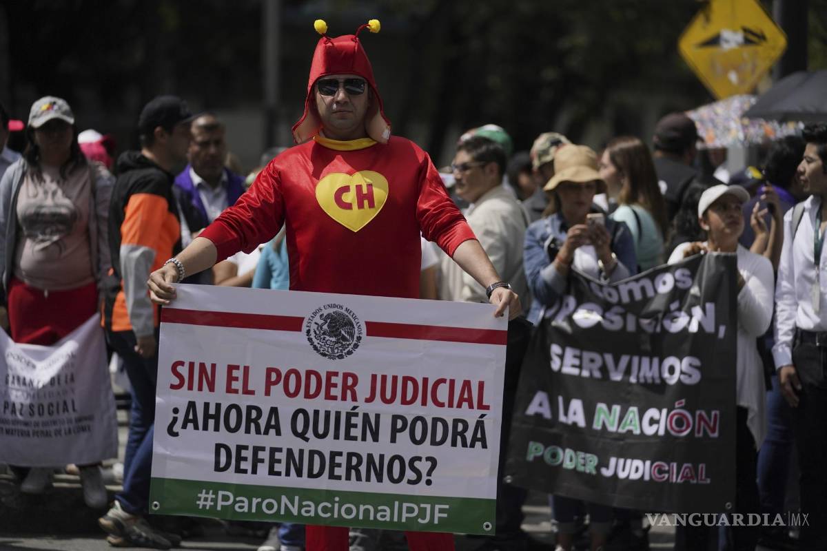 $!El trabajador judicial Jorge Reyes, vestido como el Chapulín Colorado, con un cartel que dice: “Sin poder judicial, ¿quién podrá defendernos ahora?” afuera del Senado.