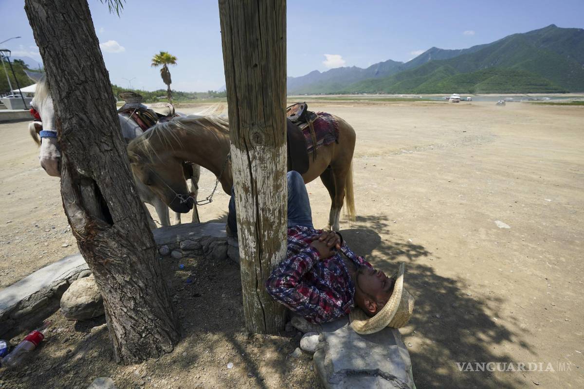 $!Juan Hernández duerme mientras espera a los clientes que quieren montar a caballo a lo largo de la playa en el embalse La Boca.