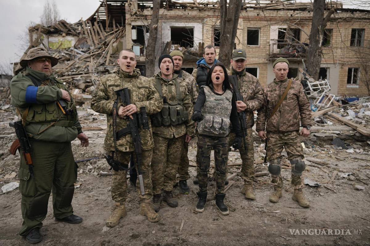 $!Combatientes ucranianos cantan una canción patriótica entre edificios destruidos en los combates entre fuerzas rusas y ucranianas en Borodyanka, Ucrania.