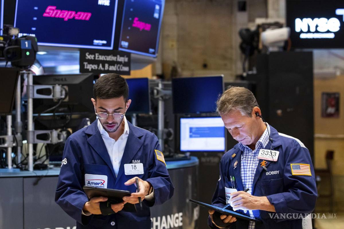 $!En esta fotografía proporcionada por la Bolsa de Valores de Nueva York, los corredores Orel Partush (i) y Robert Charmak.