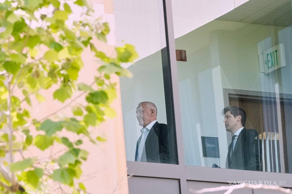 $!Sam Altman, a la derecha, es visto a través de una ventana mientras camina por un pasillo dentro del Tribunal de Distrito de los Estados Unidos en Oakland.