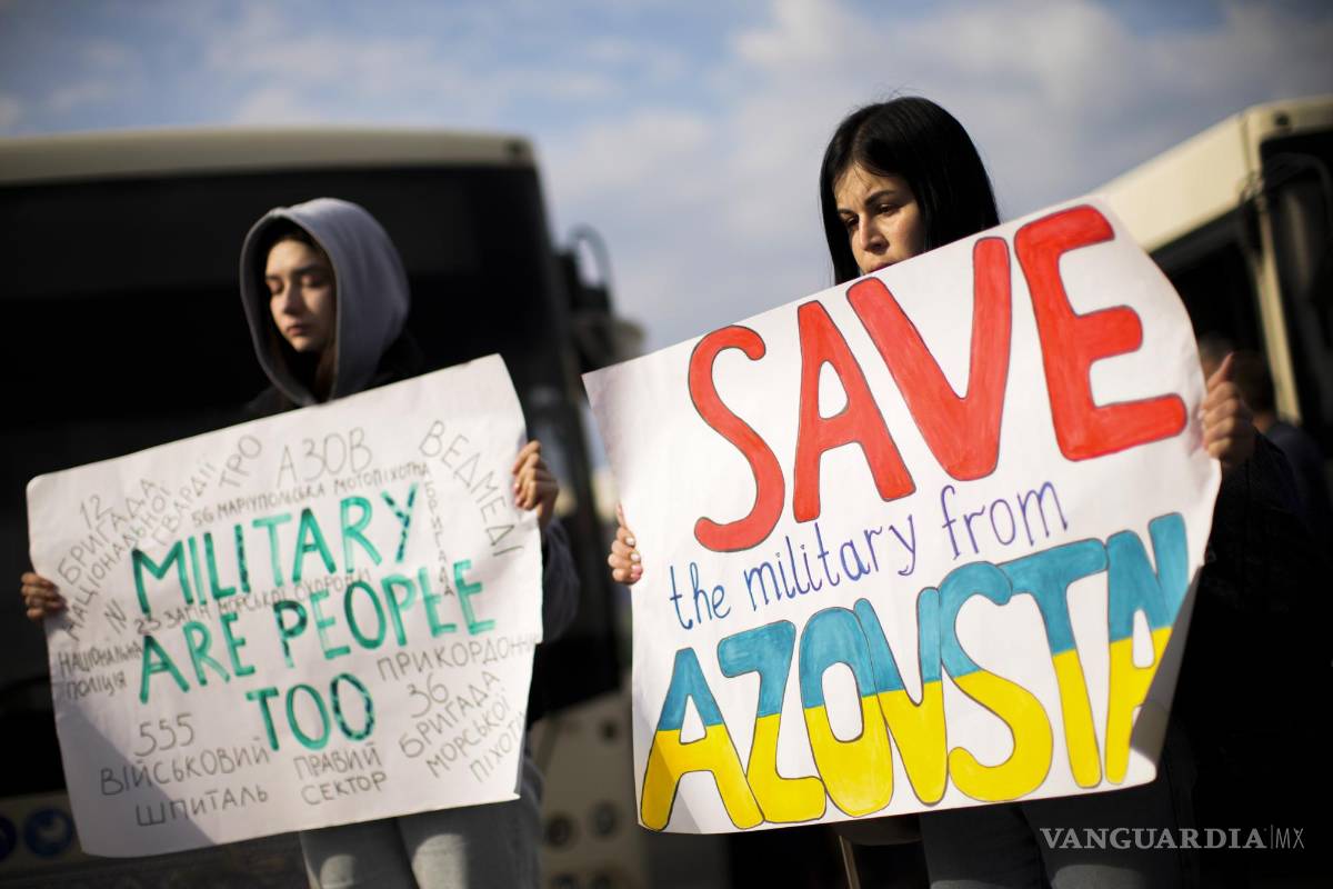 $!Dos mujeres sostienen carteles mientras las personas que huyeron de la planta de acero Azovstal en Mariupol y otras ciudades llegan a Zaporizhzhia, Ucrania.