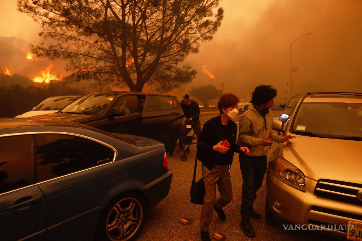 $!La gente huye del avance del incendio Palisades, en automóvil y a pie, en el vecindario Pacific Palisades de Los Ángeles.
