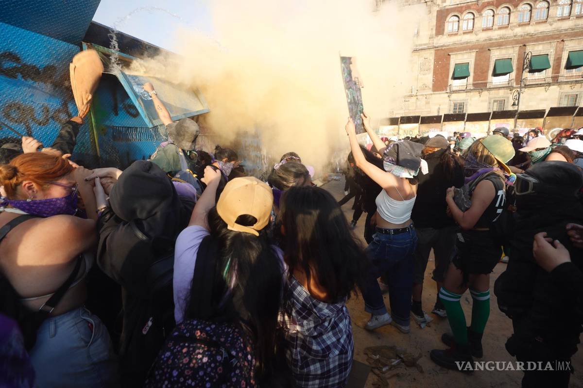 $!Mujeres intentan derribar una valla de acero durante una marcha con motivo del Día Internacional de la Mujer, en Ciudad de México (México).