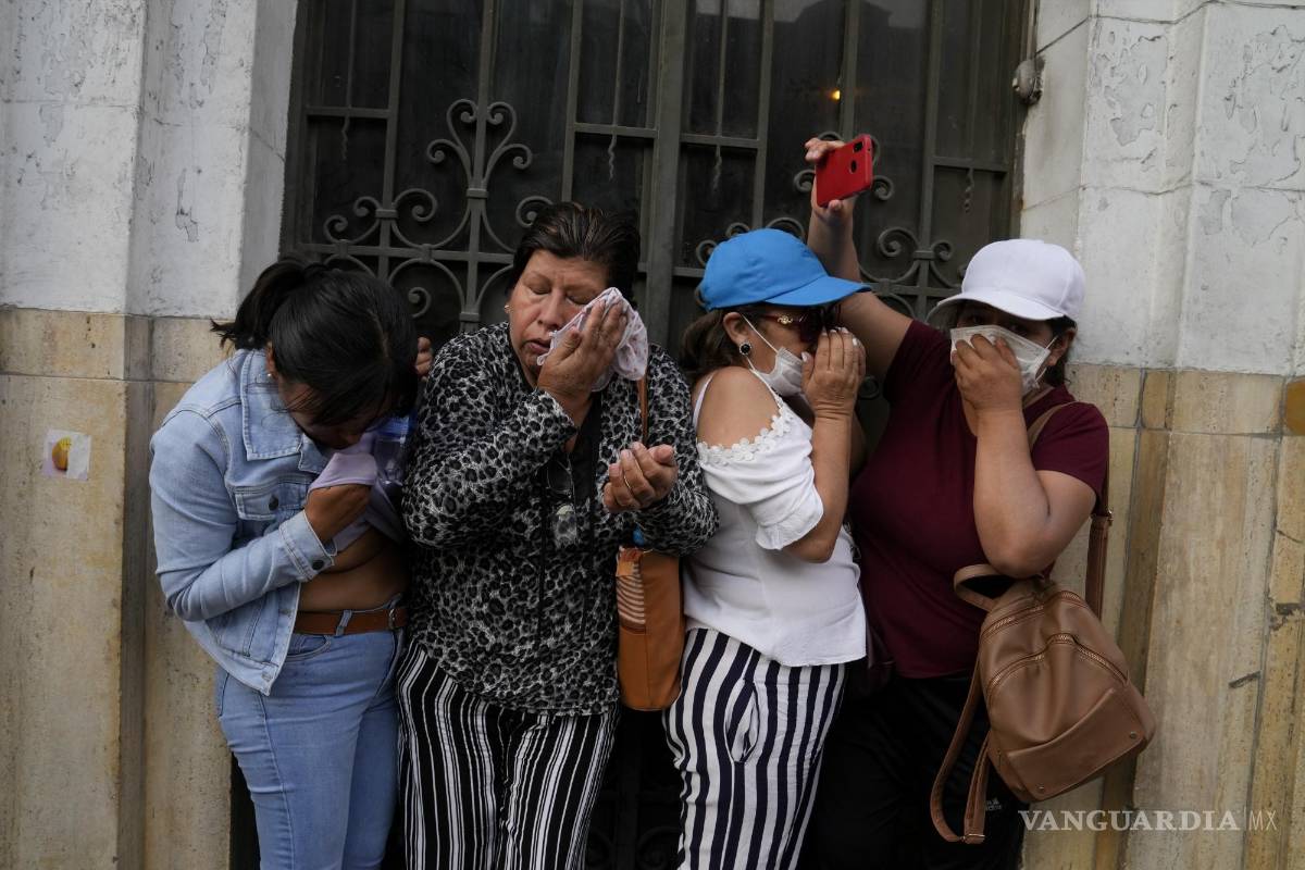 $!Mujeres se cubren del humo de bombas lacrimógenas arrojadas por la policía durante los enfrentamientos con manifestantes opositores en Lima, Perú.