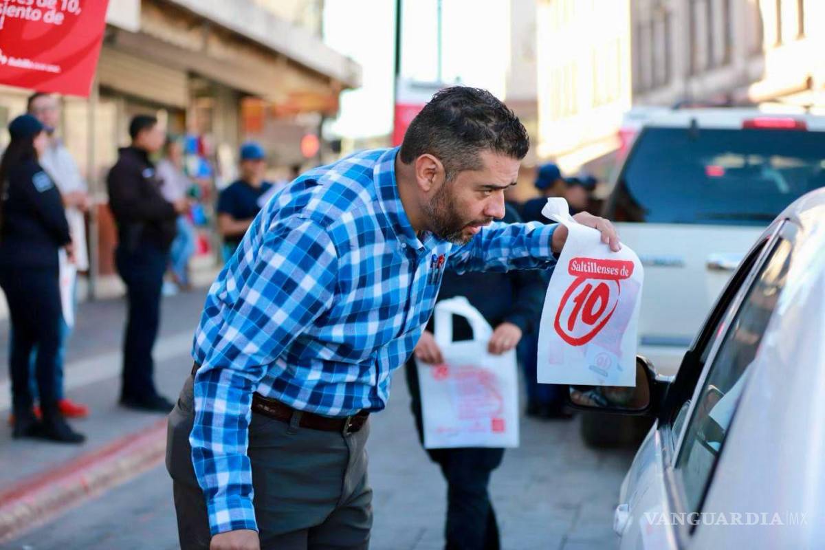 $!Ciudadanos observan carteles informativos sobre las reglas de tránsito mientras transitan por el centro de Saltillo.