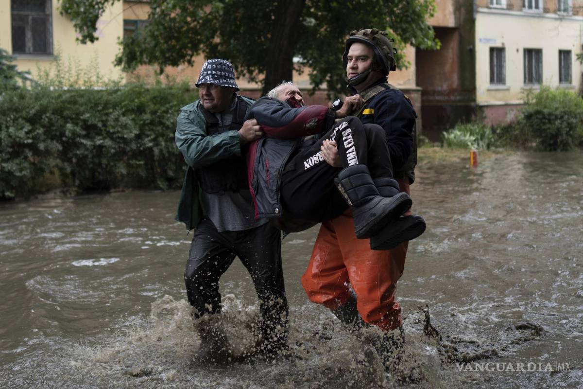 $!Equipos de rescate ayudan a trasladar a zona segura a un hombre que fue atacado por las fuerzas rusas mientras intentaba huir por barco de la inundada orilla oriental ocupada por Rusia del río Dniéper a Jersón, controlada por Ucrania, en la orilla occidental en Jersón, Ucrania, el domingo 11 de junio de 2011. (AP Foto)