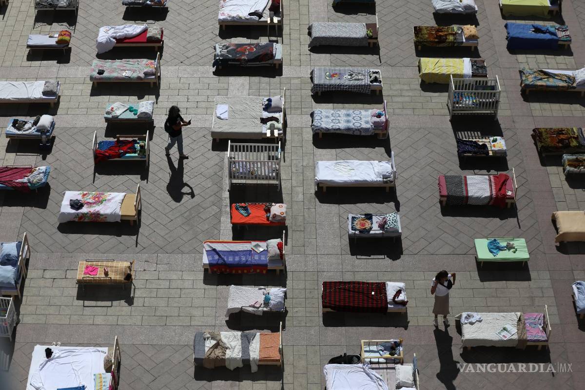 $!Personas mira algunas de las 230 camas vacías que representan a los rehenes retenidos por Hamás en Gaza en la Plaza del Municipio de Jerusalén.