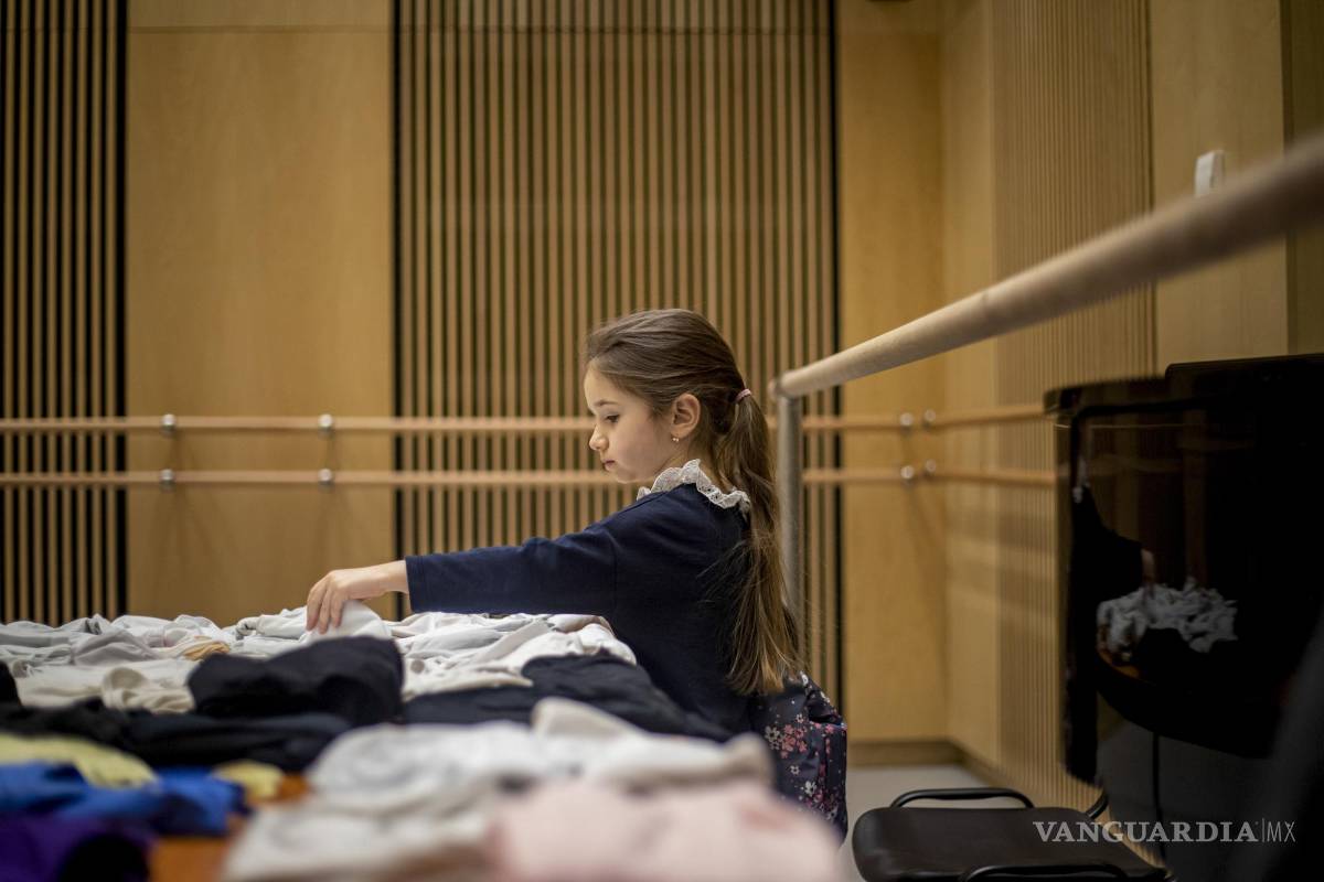 $!Una niña elige ropa de baile recolectada antes de la lección de ballet organizada por la Escuela Preparatoria de Ballet del Teatro Nacional.