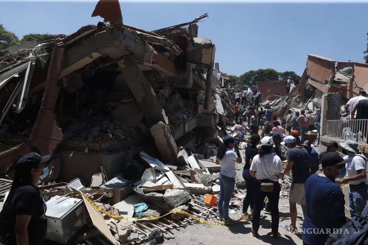 $!AME7696. CALI (COLOMBIA), 10/08/2026.- Personas observan los escombros de edificaciones colapsadas por el terremoto de magnitud 7,4 que sacudió esta mañana el país, este lunes en Cali (Colombia). El Gobierno colombiano declaró la situación de desastre nacional por el terremoto que deja al menos 71 personas fallecidas en el país, 29 de ellas en ciudades capitales.